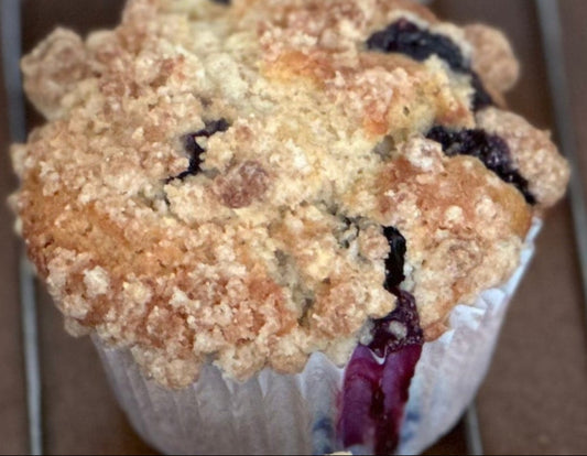 Blueberry muffins on a cooling rack with a brown background