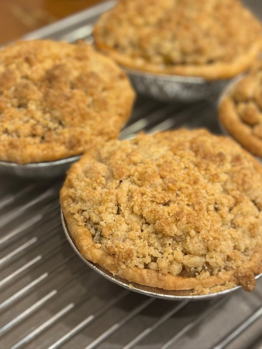Four pies on a cooling rack with a blurred background